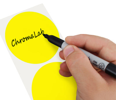 A Person's hand writing the word ChromaLabel on a sticker with a felt tip marker