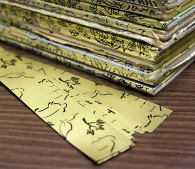Gold-Book Repair Tape strips beside a stack of gold-spined books